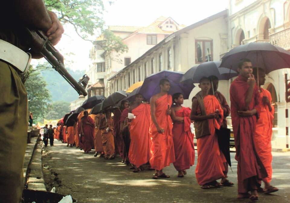 Med humanistisk blikk: Ville fredsprosessen på Sri Lanka sett annerledes ut om man hadde hatt en bred sosiokulturell forståelse av konflikten? Humaniora kunne for eksempel bidratt til å forstå buddhistisk nasjonalisme bedre. Her blir buddhistiske munker passet godt på av væpnet politi i Colombo.Foto: Gemunu Amarasinghe / NTB Scanpix