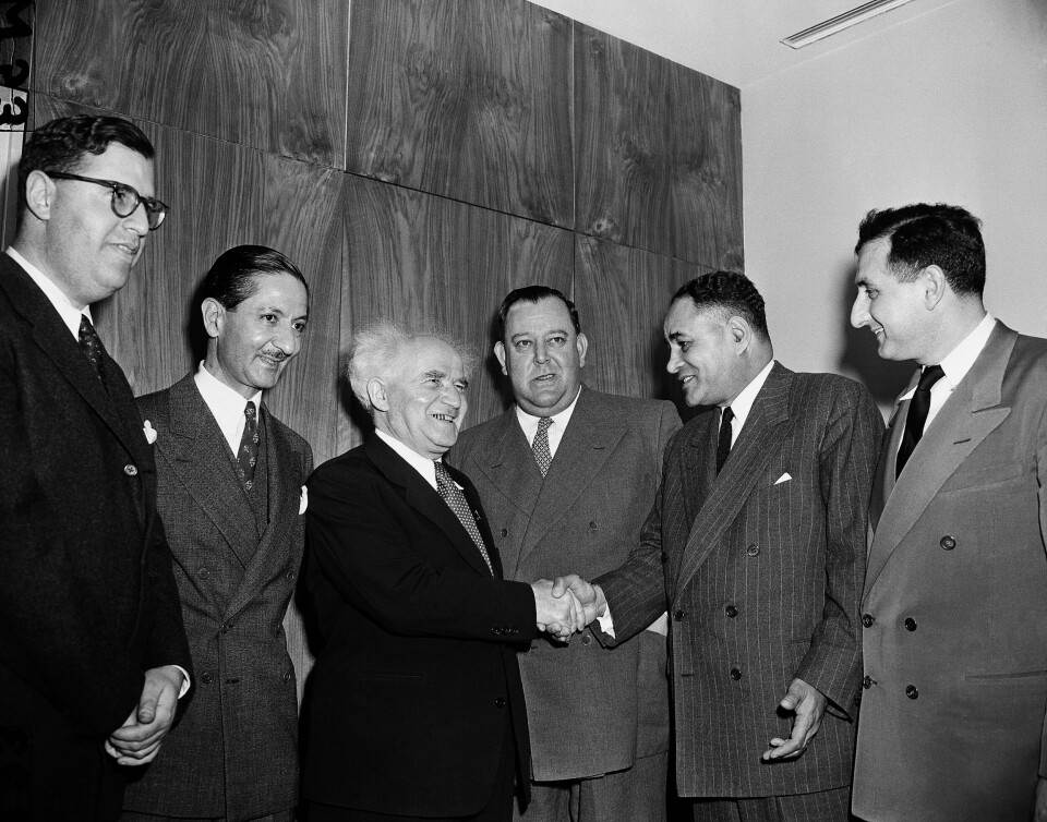 Ralph Bunche (nummer to fra høyre) i FNs hovedkvarter i september 1951, året etter at han som den første fargede personen ble tildelt Nobels fredspris. Her hilser han på Israels statsminister David Ben-Gurion. Mellom dem står nordmannen Trygve Lie, som var FNs generalsekretær.