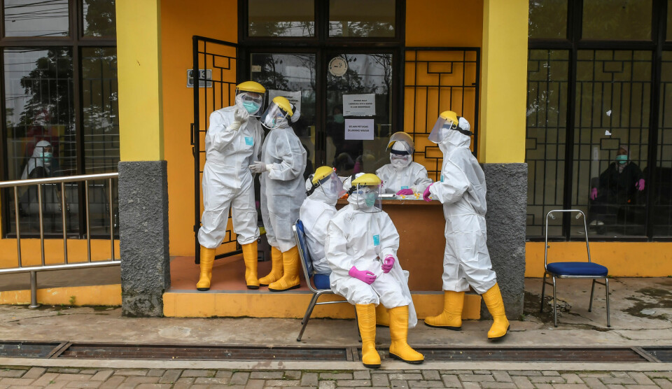 Krigføring mot skadelige mikroorganismer: Personalet gjør seg klare ved en drive-through-stasjon for koronatesting i Depok, nær Jakarta 29. mars. Foto: Muhammad Adimaja/ Antara / Reuters / NTB scanpix