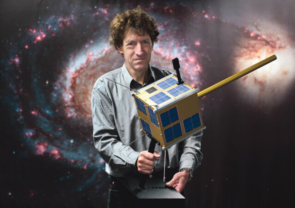 Naturlig størrelse: Romfart ble aldri kolonisering av andre planeter, men nå har vi på et vis landet på en komet. Ellers er satellitter blitt nær hverdagslig. Her står Bo N. Andersen med en modell i naturlig størrelse av den norskproduserte satelitten AISSat-1, som overvåker havområder. Foto: Ellen Lande Gossner