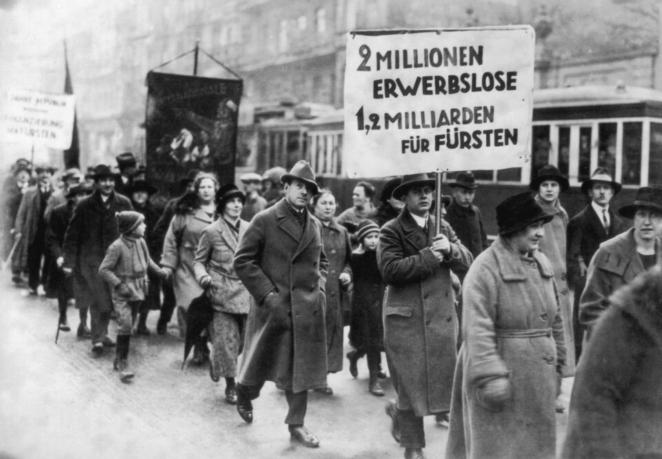 Male and female protestors carrying a banner, which reads '2 millionen erwerbslose, 1,2 milliarden fur fursten' during a demonstration by unemployed people of Berlin, Germany, circa 1930. The sign roughly translates as '2 million unemployed 1.2 billion for princes'. (Photo by Hulton Archive/Getty Images)