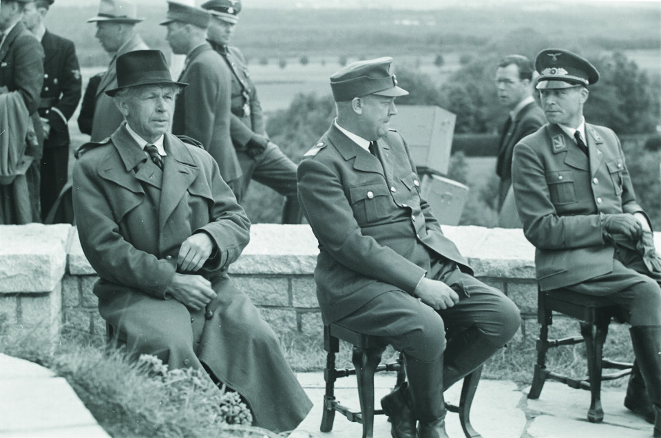 Sentralt plassert: Carl Henrik Grøndahls bok Fylkesføreren levner ingen tvil om at forfatterens far Torbjørn Eggen «handlet ut fra en nærmest fanatisk tro på Quisling og de nazistiske ideer». Her sitter Eggen (til høyre) sammen med Quisling og venter på bautaen som skal avdukes på riksmøtet til Nasjonal Samling på Stiklestad i 1944. Til venstre: Billedhugger Wilhelm Rasmussen. -