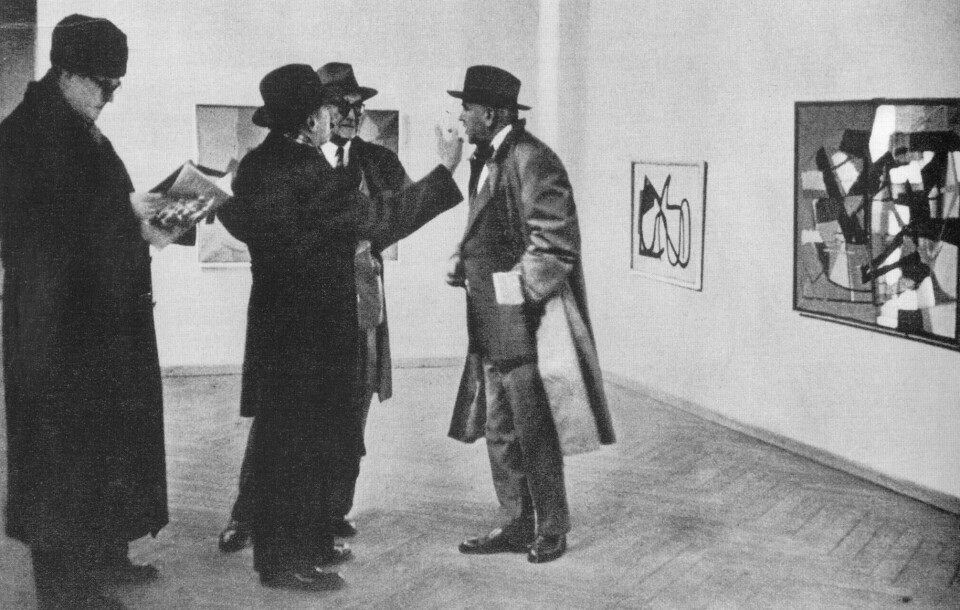 På befaring: Den danske Gallerikommissionen i arbeid i 1950. Billedbladet rapporterer: «Ved den abstrakte maler Richard Mortensens vegg ble det vill uenighet. Vilh. Lundstrøm forøker å overtale Andreas Møller til å stemme for å kjøpe et bilde, Leo Swane stritter imot med munn og armer, billedhuggeren Arnoff Thomsen holder seg borte fra kampplassen. Leo Swane seiret.» Foto fra boken Statens museum for kunst 1887–1952 av Villads Villadsen/Gyldendal