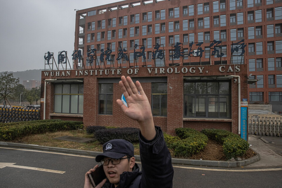 Hit, men ikke lenger: En sikkerhetsvakt prøver å forhindre fotografen I å ta bilde av Wuhan Institute of Virology i Kina. Alle steiner må snus for å finne ut hvordan viruset oppsto, og da kan ikke deler av debatten legges lokk på, skriver Sigrid Bratlie. .